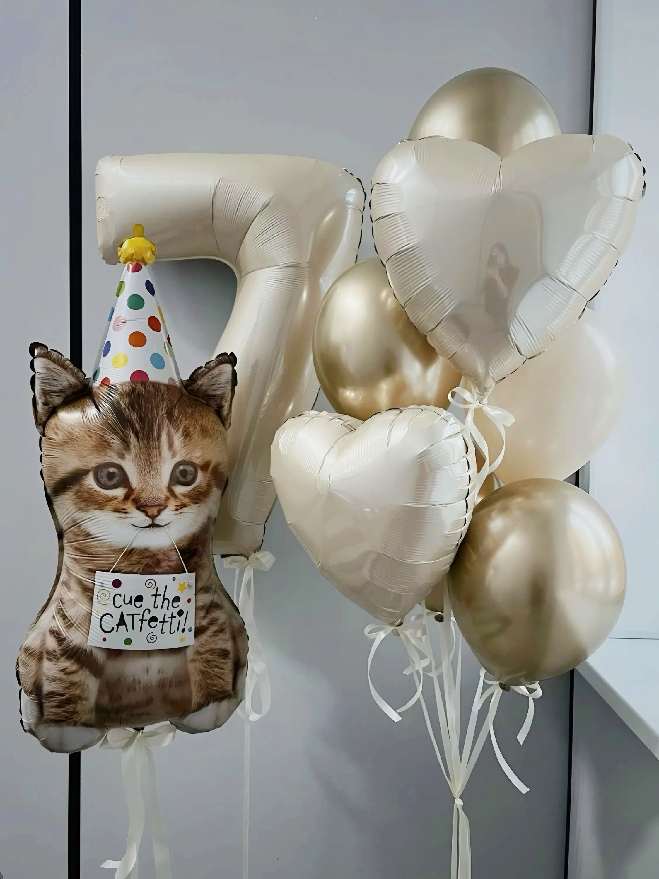 Композиция на 7 лет для девочки с кремовой цифрой 7, фольгированным котёнком, сердцами и бело-золотыми воздушными шарами