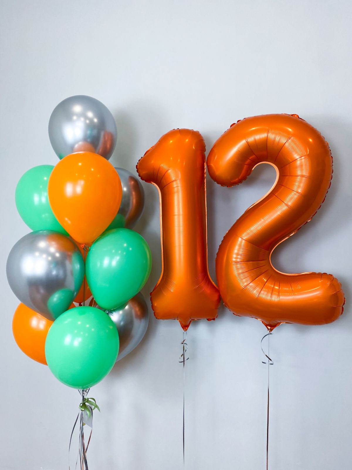 Композиция на 12 лет для мальчика с оранжевыми цифрами 12 и зелено-серебряными воздушными шарами